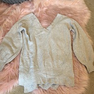 Deep v-neck sweater with puffy sleeves.